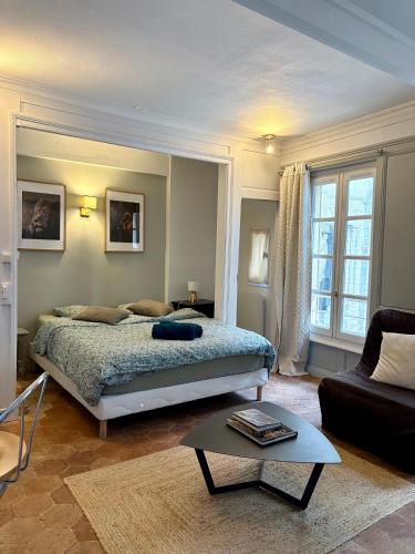 a bedroom with a bed and a couch and a table at Studio parvis Cloitre Notre Dame in Chartres