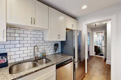 a kitchen with white cabinets and a stainless steel refrigerator at 3 Mi to Dtwn Charlotte! Quiet Haven with Fenced Yard in Charlotte