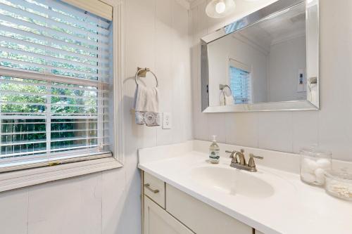 a white bathroom with a sink and a mirror at 3 Mi to Dtwn Charlotte! Quiet Haven with Fenced Yard in Charlotte