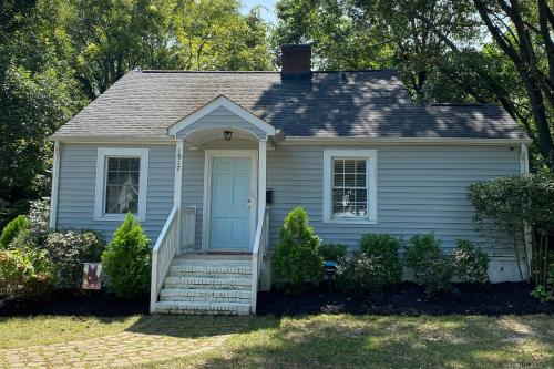 a small white house with a blue door at 3 Mi to Dtwn Charlotte! Quiet Haven with Fenced Yard in Charlotte