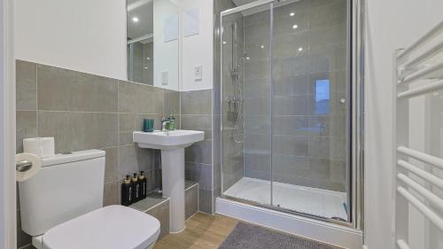 a bathroom with a shower and a toilet and a sink at 2-Bedroom Modern apt with Gym, roof terrace, Free Parking and 3 min walk to train st in Hersham