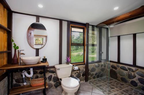 a bathroom with a toilet and a sink at Casa Cúrcuma in Turrialba
