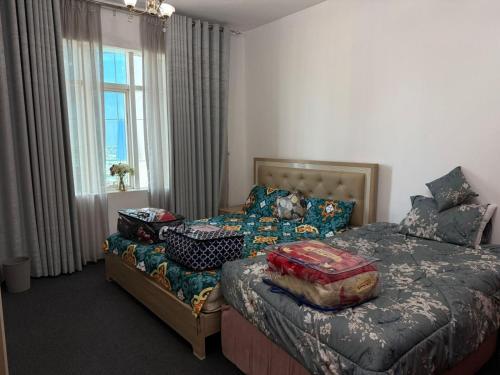 a bedroom with two beds and a window at الهورايزون in Ajman 