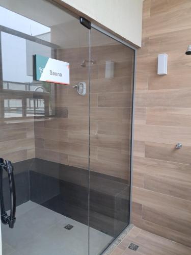 a glass shower door with a sign on it at Conforto e Lazer a 50m da Praia in Niterói