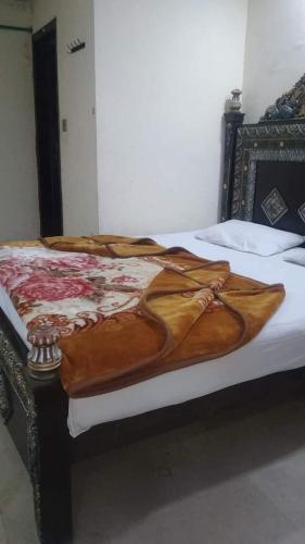 a bed with a blanket on top of it at Mall City Hotel Lahore in Lahore