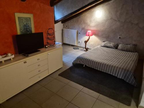 a bedroom with a bed and a flat screen tv at Julias house in Biella