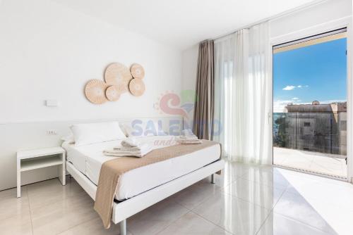 a bedroom with a bed and a large window at Residence Stella del Mare in Torre Pali