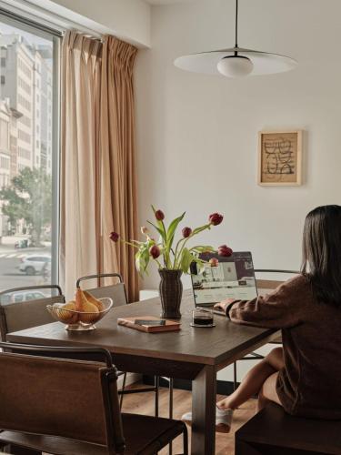 a woman sitting at a table in a living room at Mint House Washington Dc Downtown By Kasa in Washington, D.C.