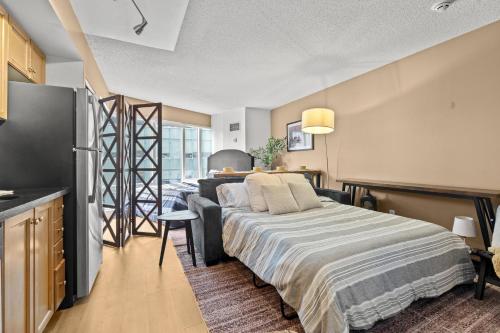 a bedroom with a large bed and a kitchen at The Pantages Suites in Toronto