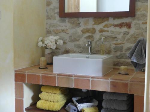 a bathroom with a sink and towels on a shelf at Studio Natur'ailes, Le Hameau du Quercy, romantique, campagne, piscine naturelle in Frontenac