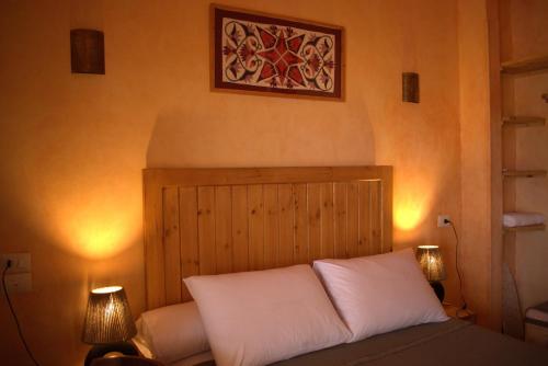 a bed with two white pillows in a room at 36 Southwalk in Quseir