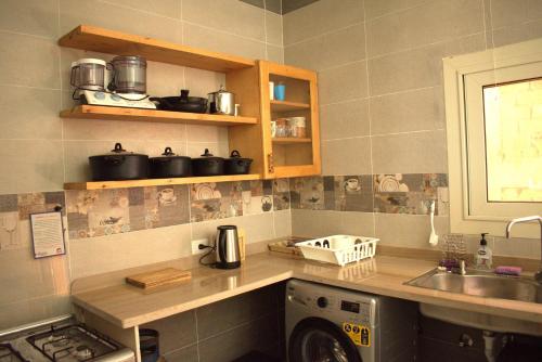 a kitchen with a sink and a washing machine at 36 Southwalk in Quseir