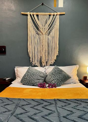 a bed with two pillows and a curtain on the wall at Departamento Luna in Valladolid