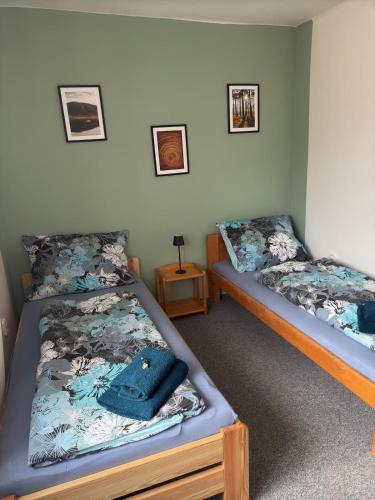 a bedroom with two beds and a blue purse on it at Přijďte pobejt in Benecko