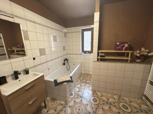 a bathroom with a tub and a sink and a bath tub at Přijďte pobejt in Benecko