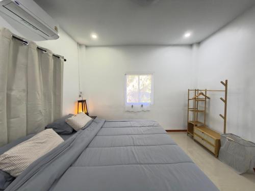 a bedroom with a large bed and a window at Baan Lanta in Ko Po