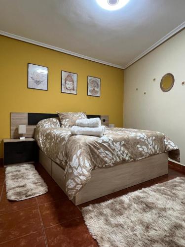 ein Schlafzimmer mit einem Bett und einer gelben Wand in der Unterkunft Sol River in Guardo