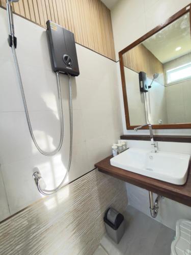 a bathroom with a shower and a sink and a mirror at Baan Lanta in Ko Po