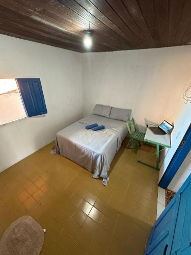 a room with a bed and a laptop on a table at CASA MARAGOGI 3 Quartos in Maragogi