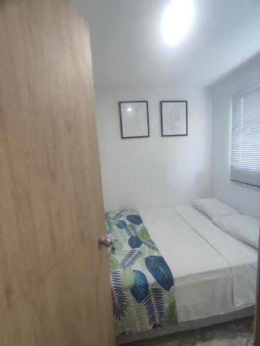 a small bedroom with a bed and a door at Via Tayrona in Santa Marta