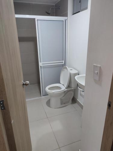 a white bathroom with a toilet and a sink at Via Tayrona in Santa Marta