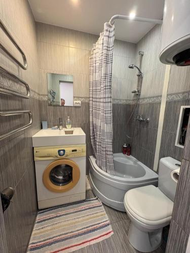 a bathroom with a toilet and a sink and a tub at Liudmila in Liepāja