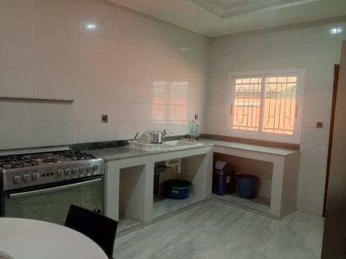 una cucina con lavello e fornello di Villa Prestige a Moanda
