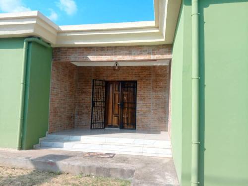 un ingresso a un edificio in mattoni con porta di Villa Prestige a Moanda