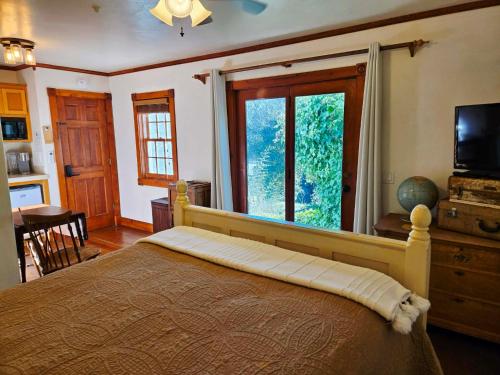 a bedroom with a bed with a television and a window at Oak Hill Inn in Julian