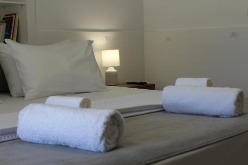 a large white bed with two pillows on it at Almyra in Finikas