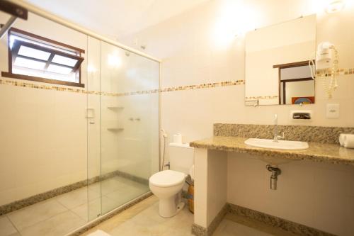 a bathroom with a toilet and a shower and a sink at Pousada Vila do Beco in Arraial d'Ajuda