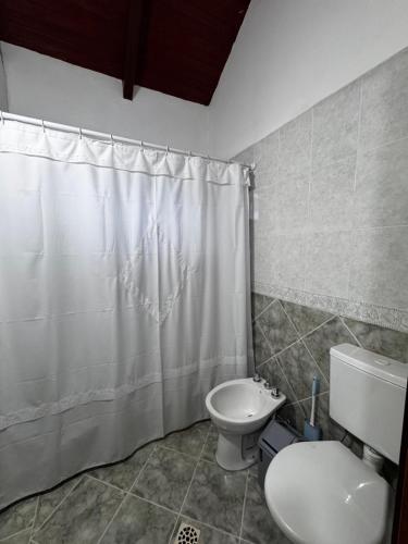 a bathroom with a toilet and a shower curtain at Casa Bati in El Mollar