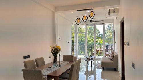 a dining room with a table and chairs at EK Breeze Kalutara in Kalutara