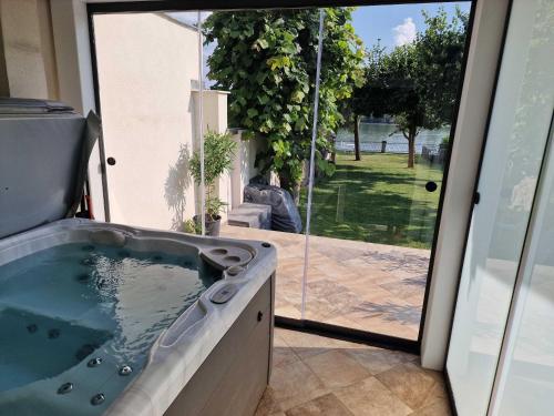 a jacuzzi tub in a house with a sliding glass door at Jacuzzi - Riverside - Garden in Kismaros