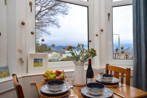 a table with a bowl of fruit and a window at Montford Shore in Rothesay