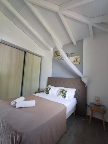 two beds in a room with white walls at LES MULTIPLIANTS in Le Moule