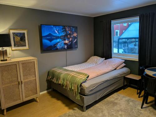 a bedroom with a bed and a tv on the wall at E&E Apartment Junior in Svolvær