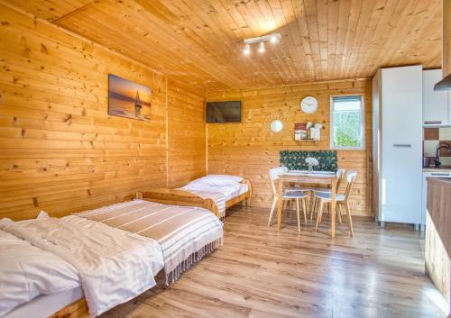 a room with two beds and a table in it at Domki parterowe ANITA in Zawóz