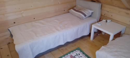 a room with a white bed and a table at Vikendica strane in Mateševo