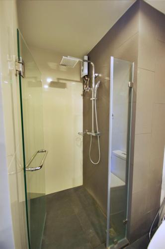 una doccia con una porta in vetro in un bagno di 6th Avenue Surin by Risa a Surin Beach