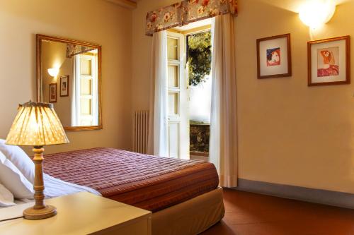 a bedroom with a bed and a window at Fattoria di Magliano Winery in Magliano in Toscana