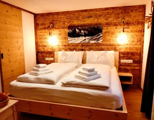 a bedroom with a bed with towels on it at B&B Luggla - sauna in camera in Predoi