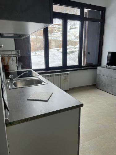a kitchen with a sink and a large window at Lemon Suite - Titty's Studio - Limone Piemonte in Limone Piemonte