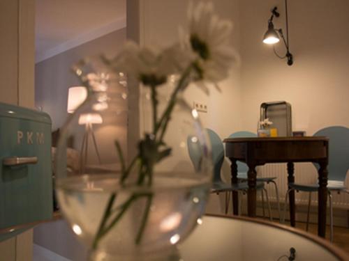 a vase with flowers sitting on a glass table at Ferienwohnung DER INSULANER in Lindau