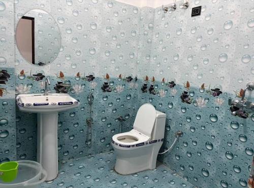 a blue bathroom with a toilet and a sink at Hotel prayagraj in Barkot