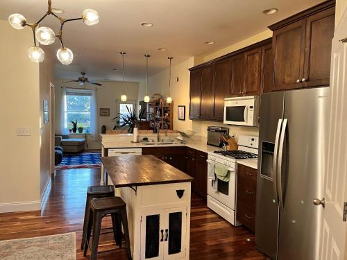a kitchen with wooden cabinets and a stainless steel refrigerator at Fox Park Gem Cozy Room with Premium Bedding & Desk in Saint Louis