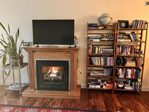 a living room with a fireplace with a flat screen tv at Fox Park Gem Cozy Room with Premium Bedding & Desk in Saint Louis