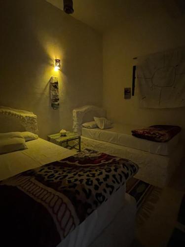 a room with two beds and a table in a room at Soliman House Siwa in Siwa