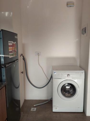 una lavatrice con un cavo collegato a una presa a muro di Confortable Apartament a La Paz