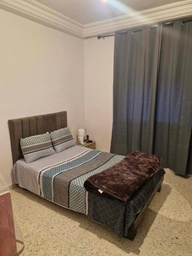 a bedroom with a bed and a window with curtains at Villa résidence privé Ariana in Ariana